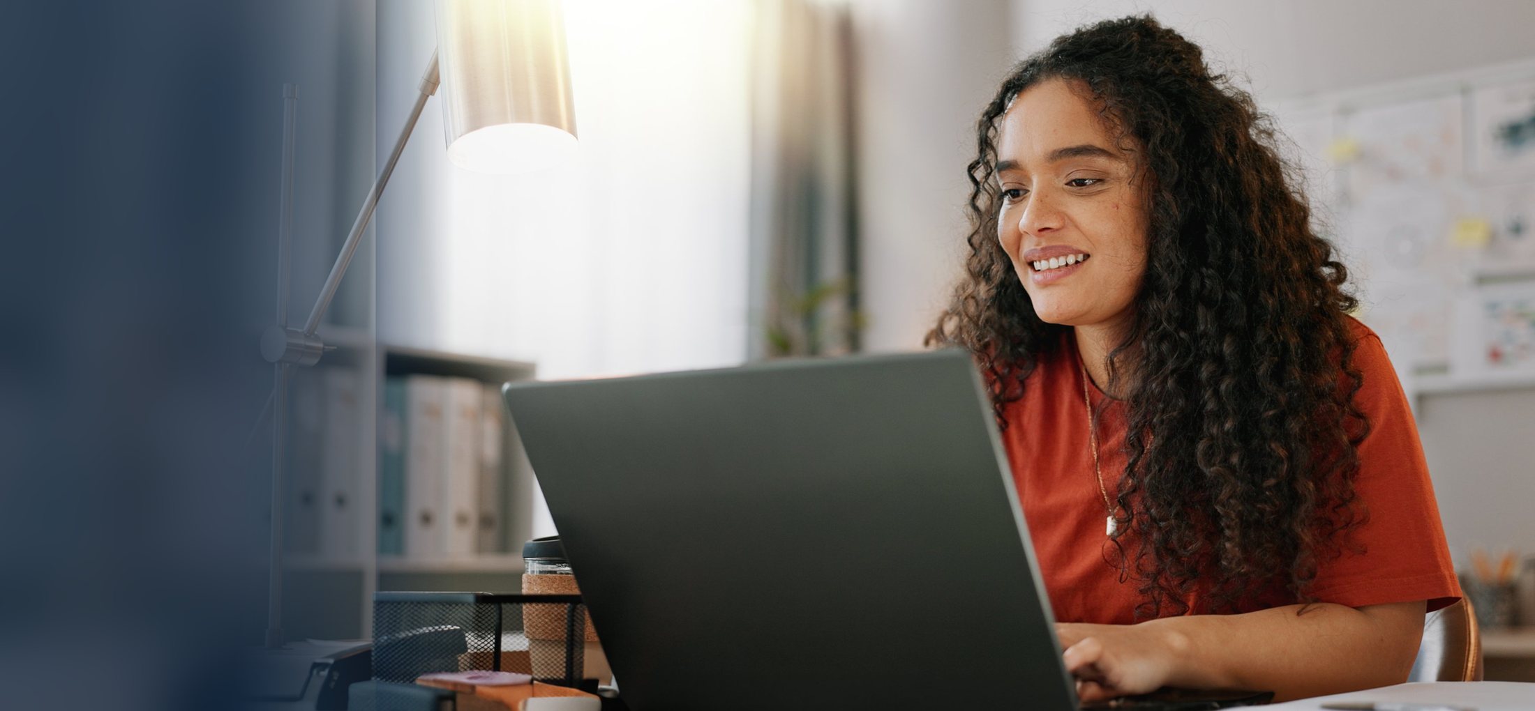 A small business owner reading at her laptop in a bright office