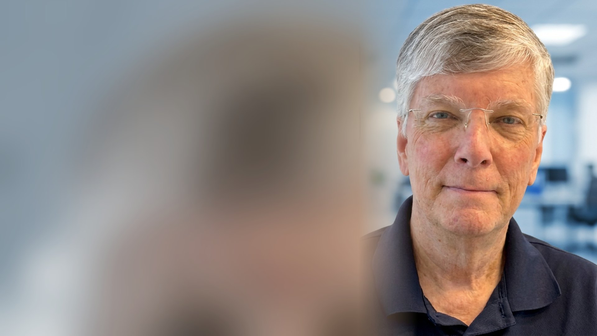 Nicky Smith, founder of Carolina Digital Phone, in a navy polo shirt in a modern office with a data center behind him