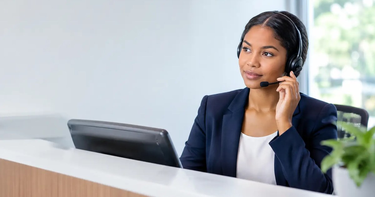 Receptionist wearing a headset at a modern front desk taking a call