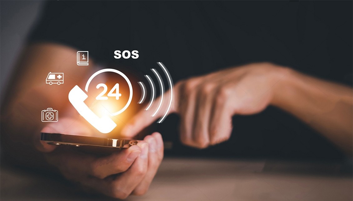 Smartphone user reaching emergency services with SOS, 24 hour response, and medical data icons representing NG911 multimedia capabilities