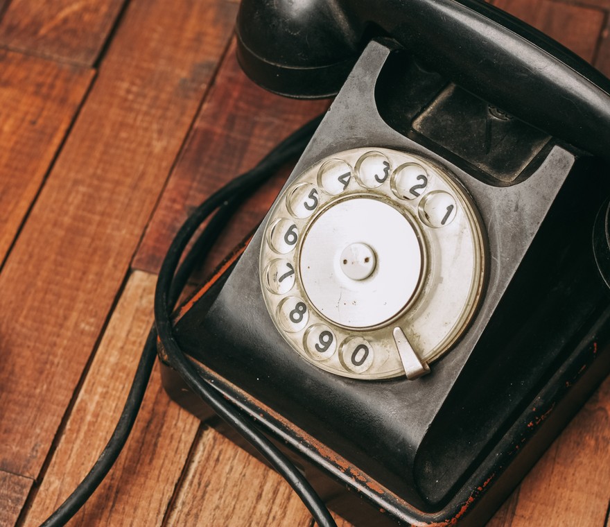 A vintage rotary telephone on a wooden surface