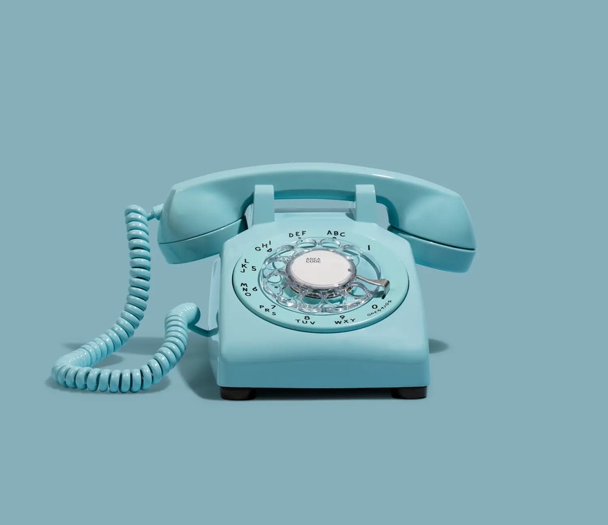 Business owner hanging up an old red desk phone